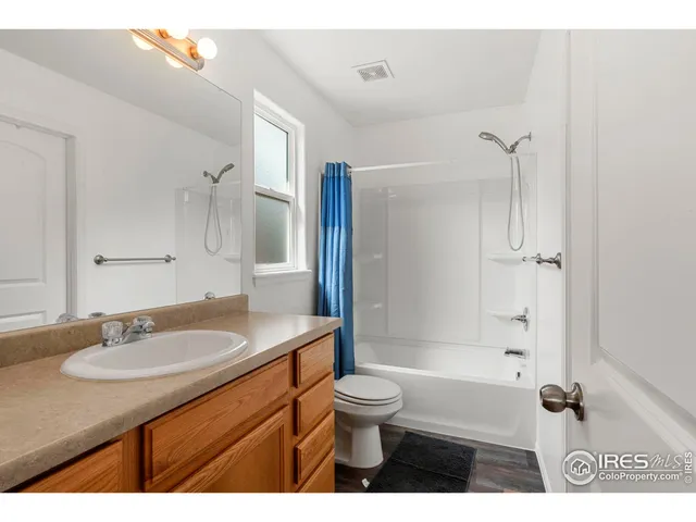 a bathroom with a granite countertop sink toilet a mirror and shower