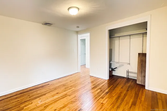 an empty room with wooden floor and a window