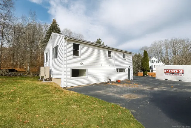 a view of a big house with a big yard and large trees