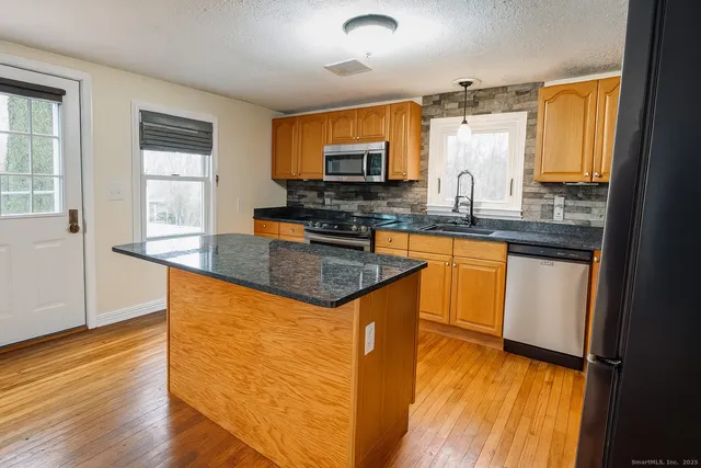 a kitchen with granite countertop a sink stove and cabinets