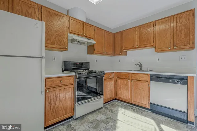 a kitchen with stainless steel appliances granite countertop a refrigerator and a stove top oven