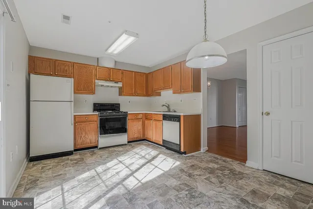a kitchen with a refrigerator a sink and cabinets