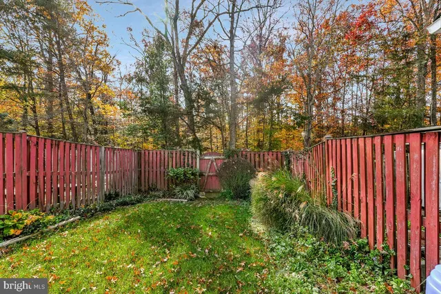 a view of garden with wooden fence