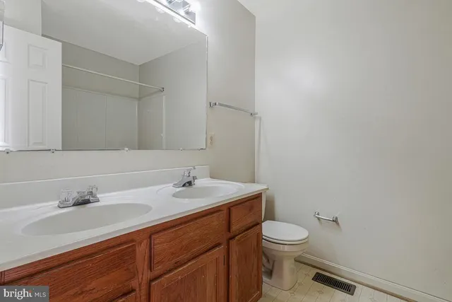 a bathroom with a granite countertop sink a toilet and a mirror