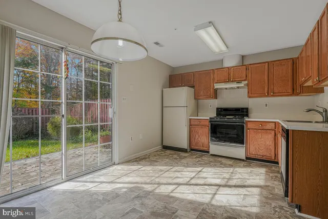 a kitchen with a refrigerator a stove and a sink