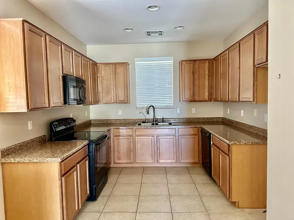 a kitchen with stainless steel appliances granite countertop a sink stove and cabinets
