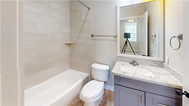 a bathroom with a granite countertop sink a toilet and a mirror