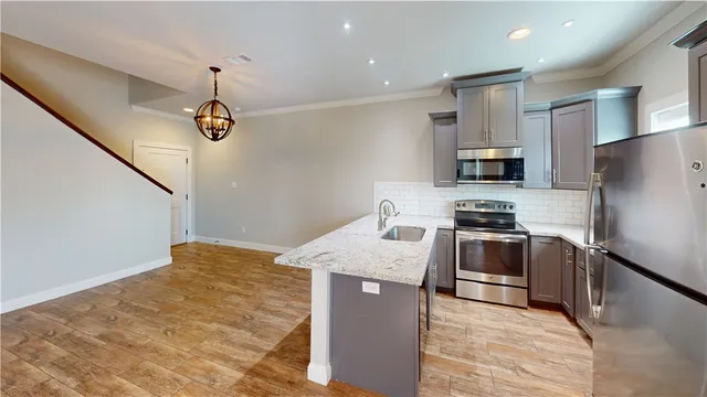 a kitchen with kitchen island a counter space a sink appliances and cabinets