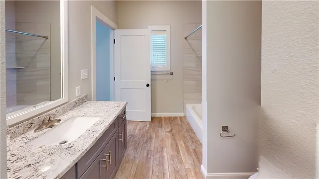 a bathroom with a granite countertop sink a toilet and shower