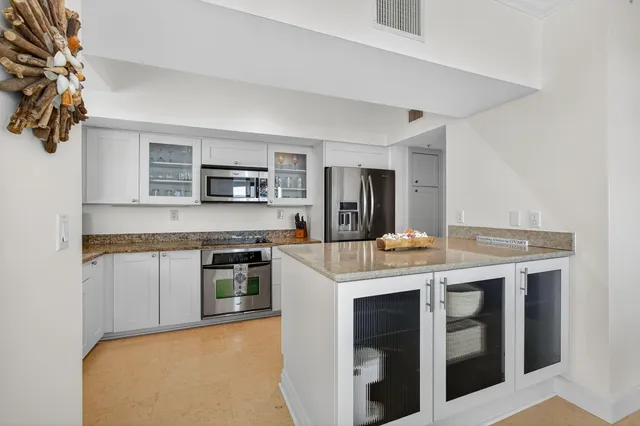 a kitchen with stainless steel appliances granite countertop a refrigerator and a sink
