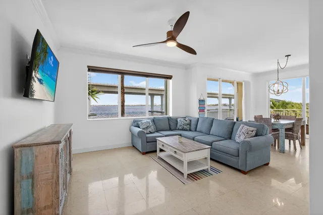 a view of a dining room and livingroom with furniture wooden floor a chandelier