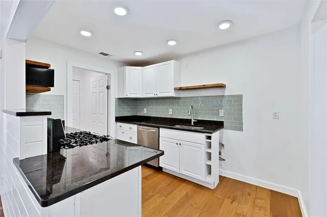a kitchen with granite countertop a sink and cabinets
