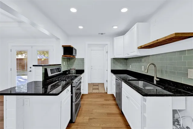 a kitchen with stainless steel appliances a sink stove and cabinets