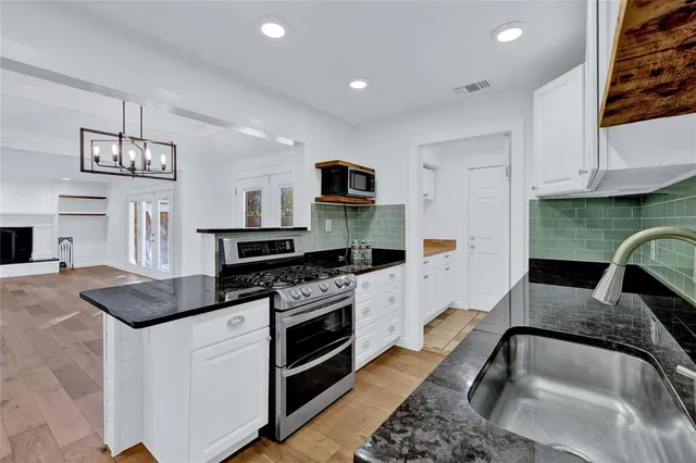 a kitchen with stainless steel appliances granite countertop a stove and a sink