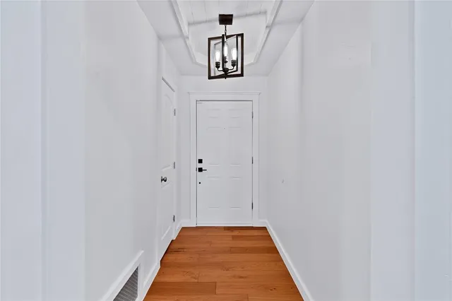 a view of a hallway with wooden floor and entryway
