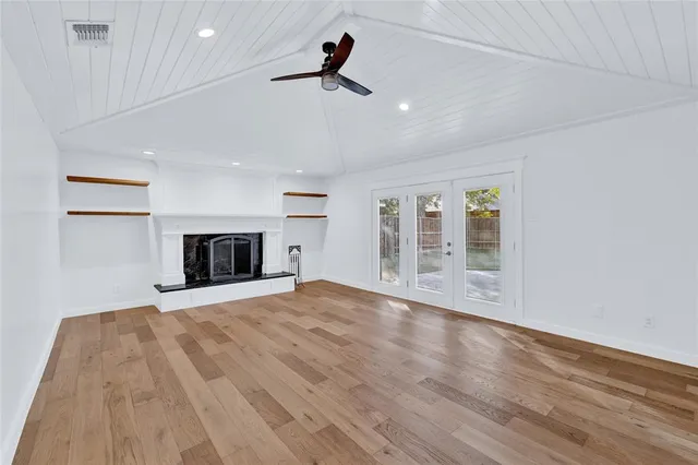 a view of empty room with wooden floor and fireplace