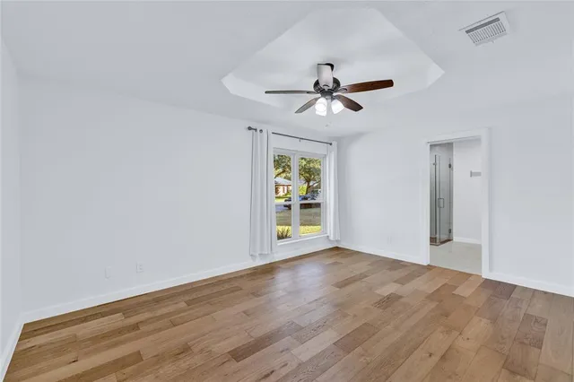 a view of room with wooden floor ceiling fan and window