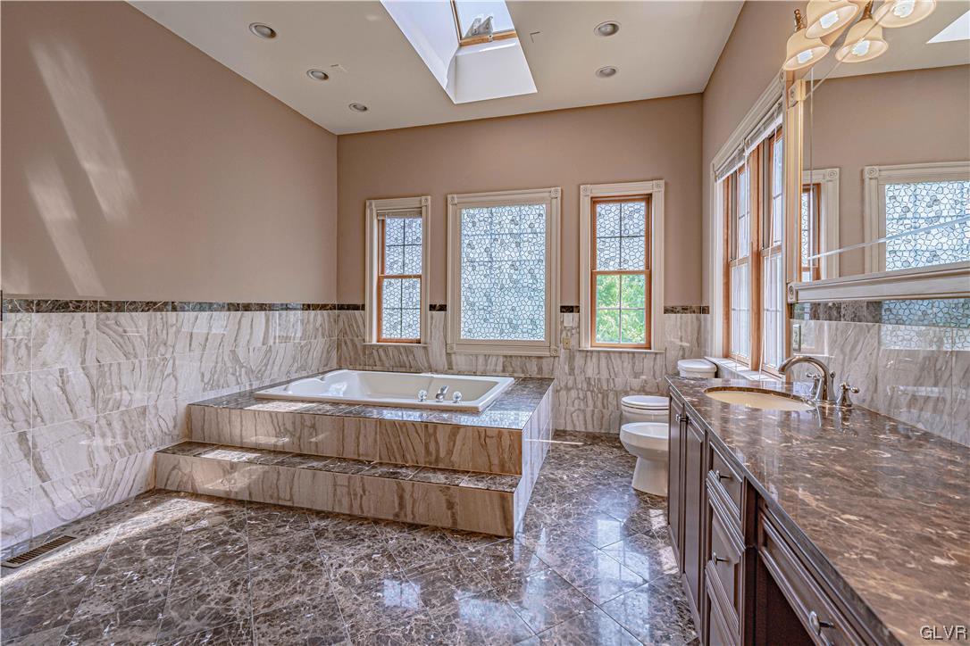 2175 Augusta Drive Center Valley, PA 18034 - Photo 33 of 50 a spacious bathroom with a granite countertop tub a sink and a large mirror
