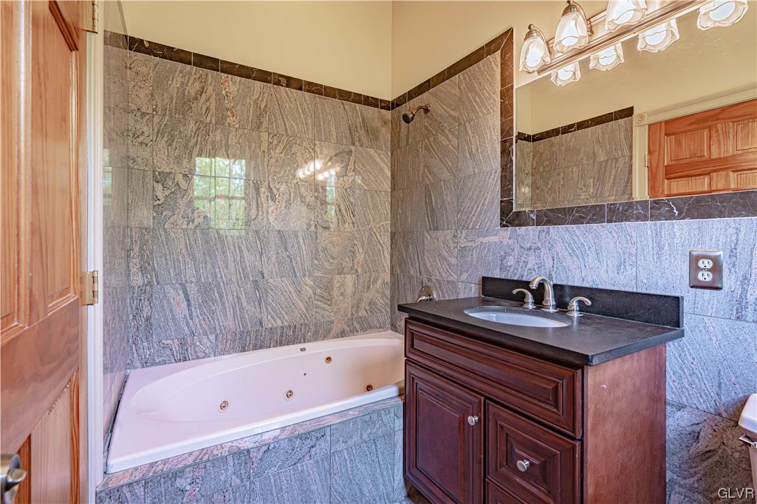 2175 Augusta Drive Center Valley, PA 18034 - Photo 42 of 50 a bathroom with a granite countertop sink and a bathtub