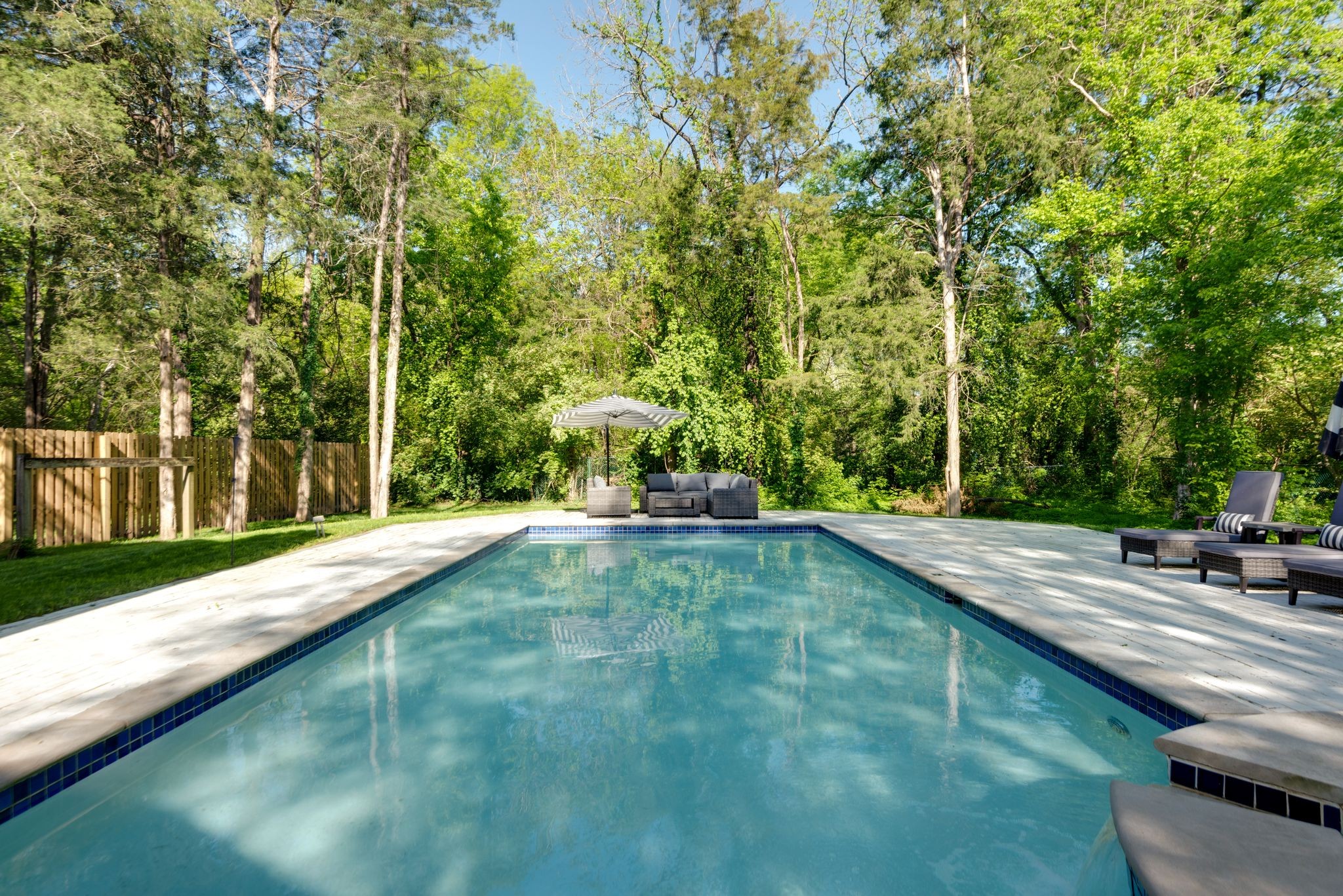 a swimming pool with trees in the background