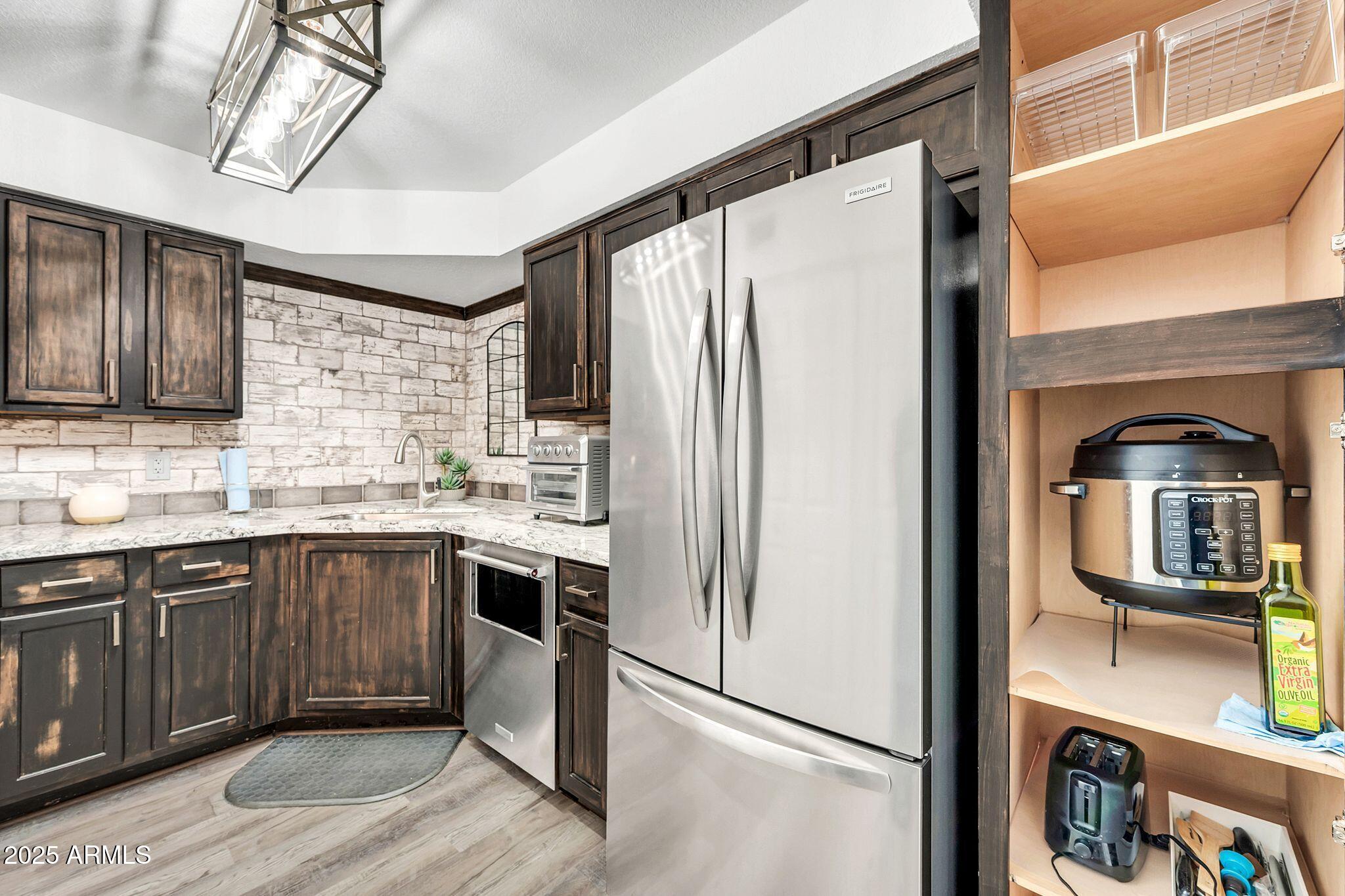8787 East Mountain View Road, Unit 2100 Scottsdale, AZ 85258 - Photo 19 of 48 a kitchen with stainless steel appliances granite countertop a refrigerator and a sink
