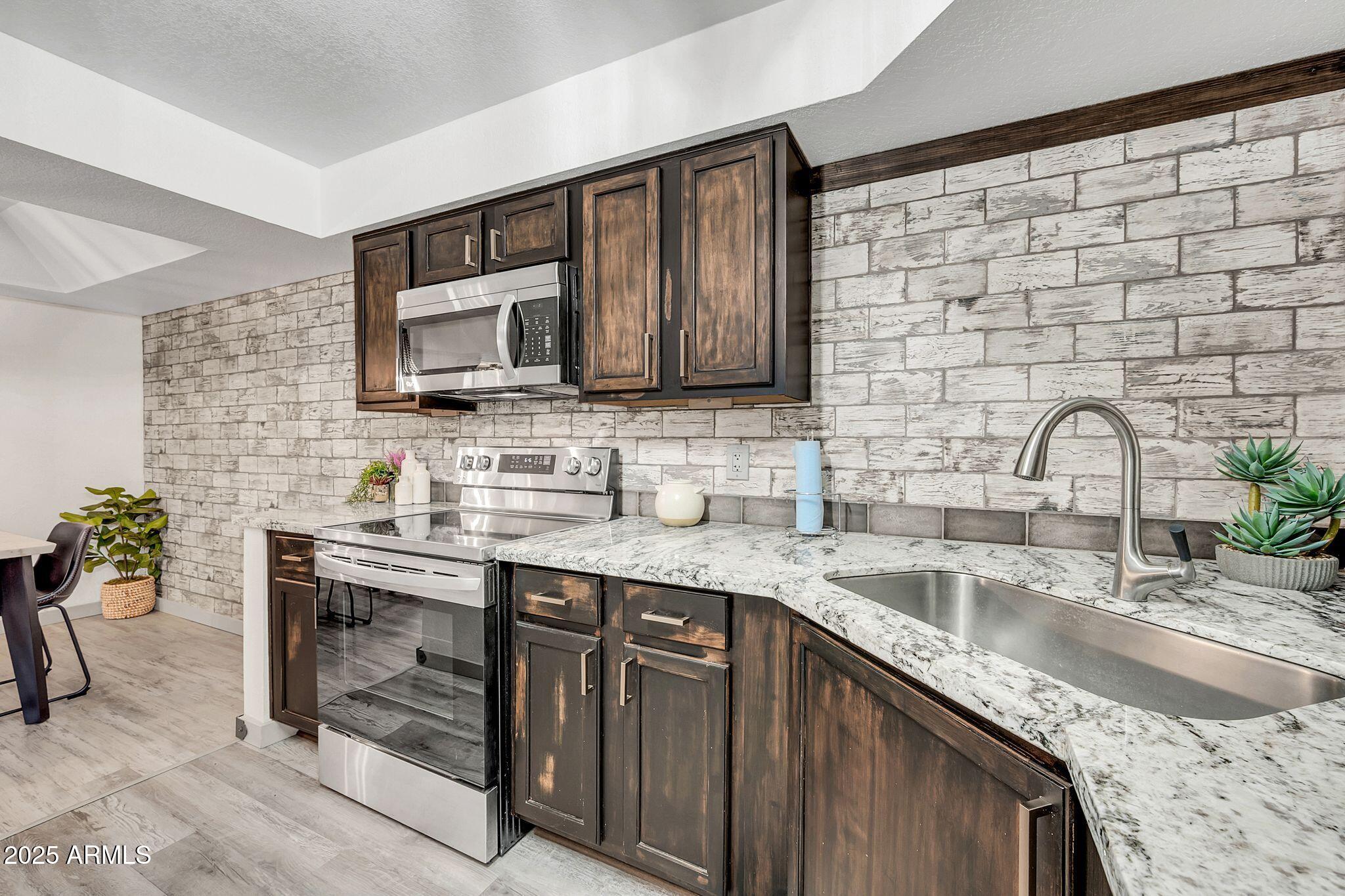 8787 East Mountain View Road, Unit 2100 Scottsdale, AZ 85258 - Photo 21 of 48 a kitchen with stainless steel appliances granite countertop a sink stove and cabinets