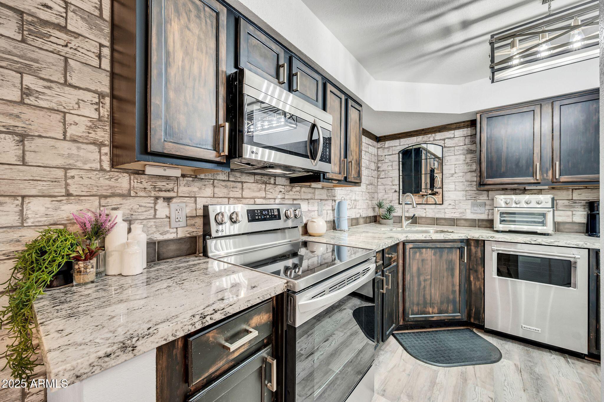 8787 East Mountain View Road, Unit 2100 Scottsdale, AZ 85258 - Photo 22 of 48 a kitchen with stainless steel appliances granite countertop a sink stove and microwave