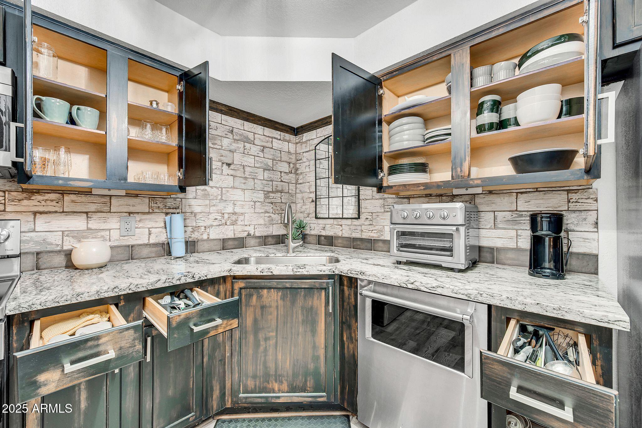 8787 East Mountain View Road, Unit 2100 Scottsdale, AZ 85258 - Photo 23 of 48 a kitchen with stainless steel appliances granite countertop a sink stove and cabinets