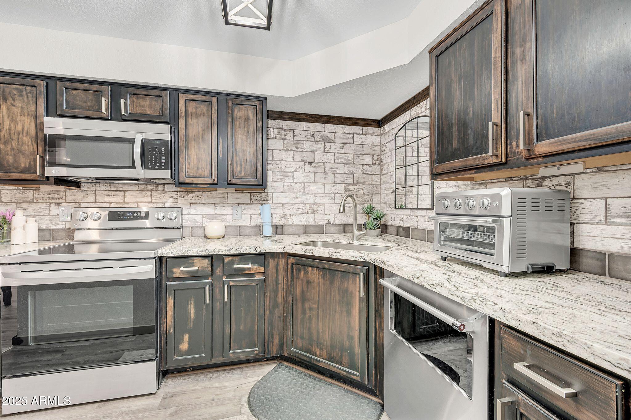 8787 East Mountain View Road, Unit 2100 Scottsdale, AZ 85258 - Photo 26 of 48 a kitchen with granite countertop stainless steel appliances and cabinets