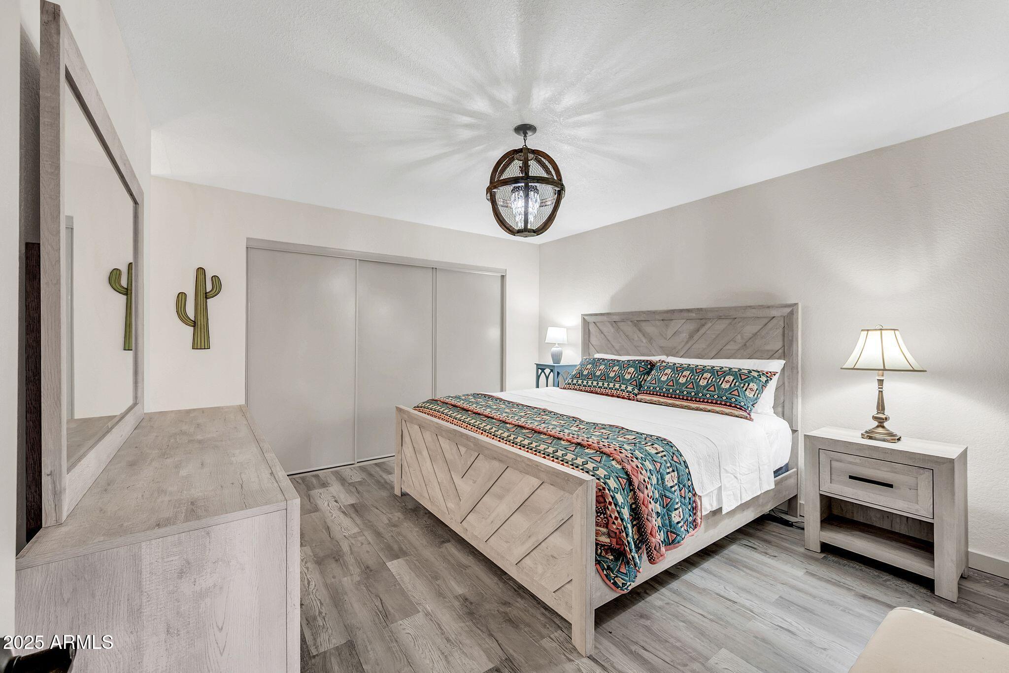 8787 East Mountain View Road, Unit 2100 Scottsdale, AZ 85258 - Photo 34 of 47 a bedroom with a bed and a chandelier