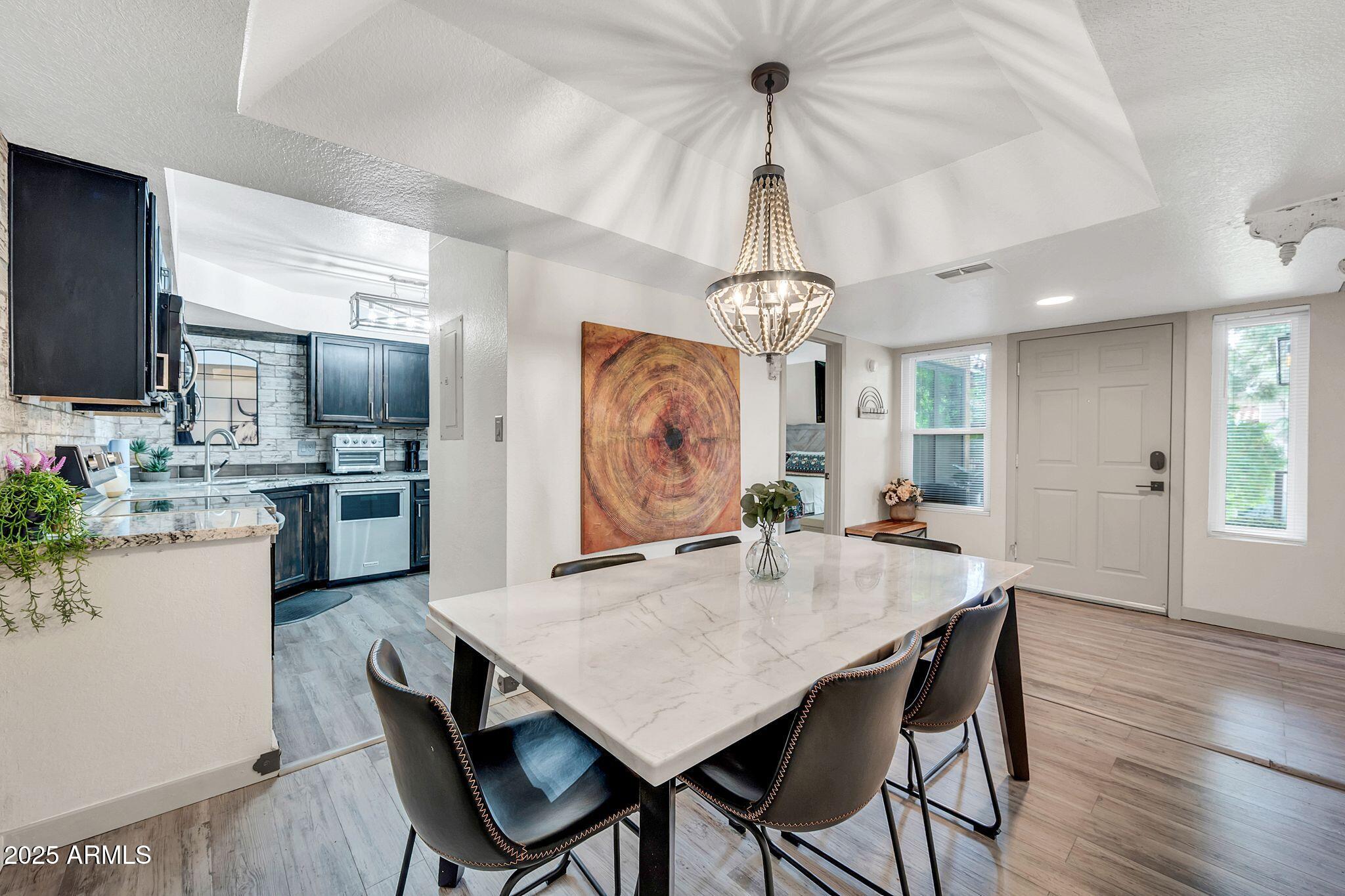 8787 East Mountain View Road, Unit 2100 Scottsdale, AZ 85258 - Photo 8 of 47 a view of a dining room and livingroom with furniture wooden floor a chandelier