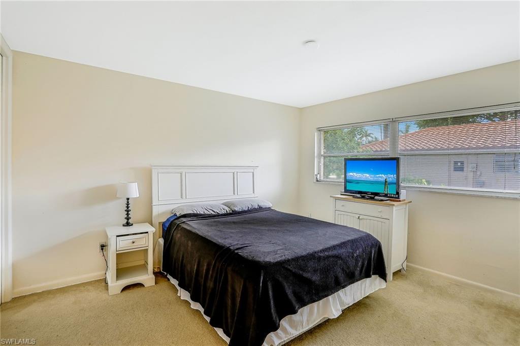 3888 Crayton Road Naples, FL 34103 - Photo 16 of 29 a bedroom with a bed and a television in it