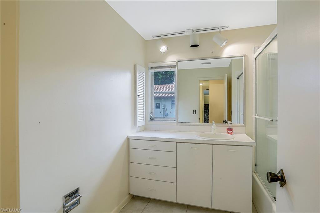 3888 Crayton Road Naples, FL 34103 - Photo 17 of 29 a bathroom with a sink and a mirror