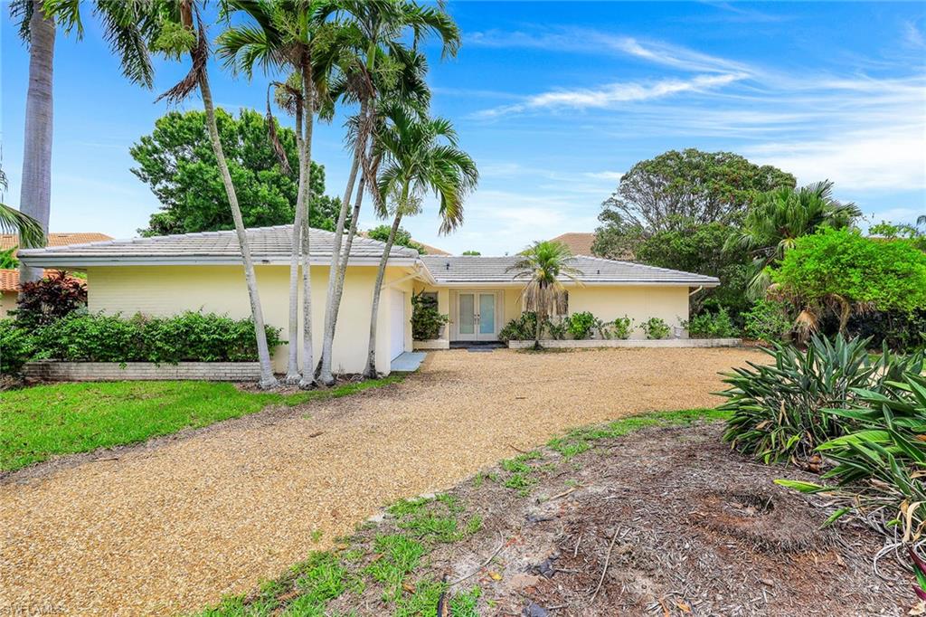 3888 Crayton Road Naples, FL 34103 - Photo 2 of 29 a front view of a house with garden