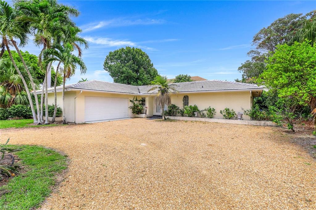 3888 Crayton Road Naples, FL 34103 - Photo 6 of 29 a front view of a house with a yard and a garage