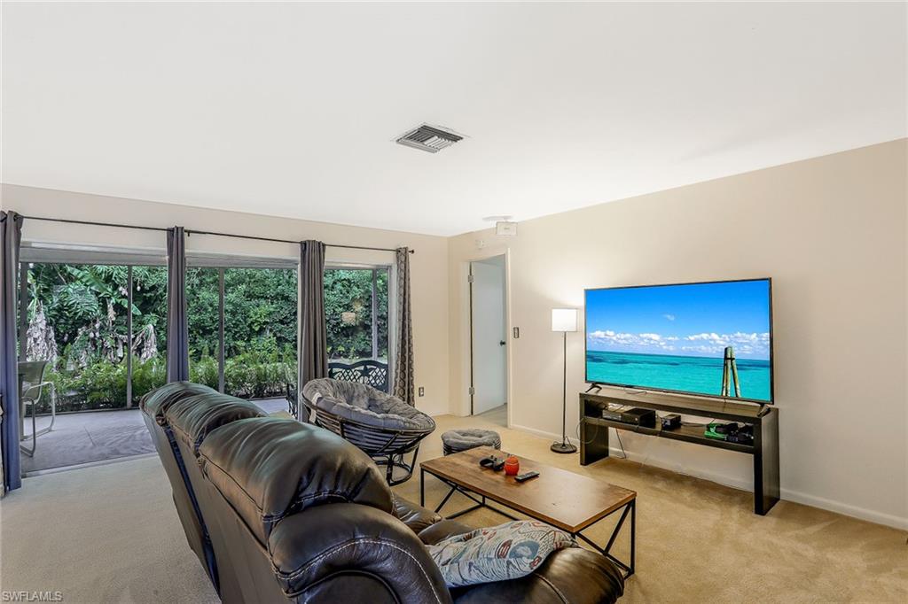 3888 Crayton Road Naples, FL 34103 - Photo 8 of 29 a living room with furniture tv and a large window