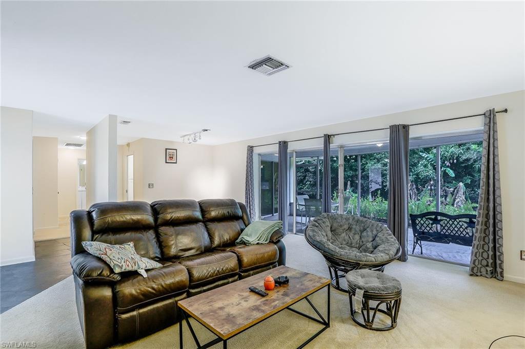 3888 Crayton Road Naples, FL 34103 - Photo 9 of 29 a living room with furniture and a large window