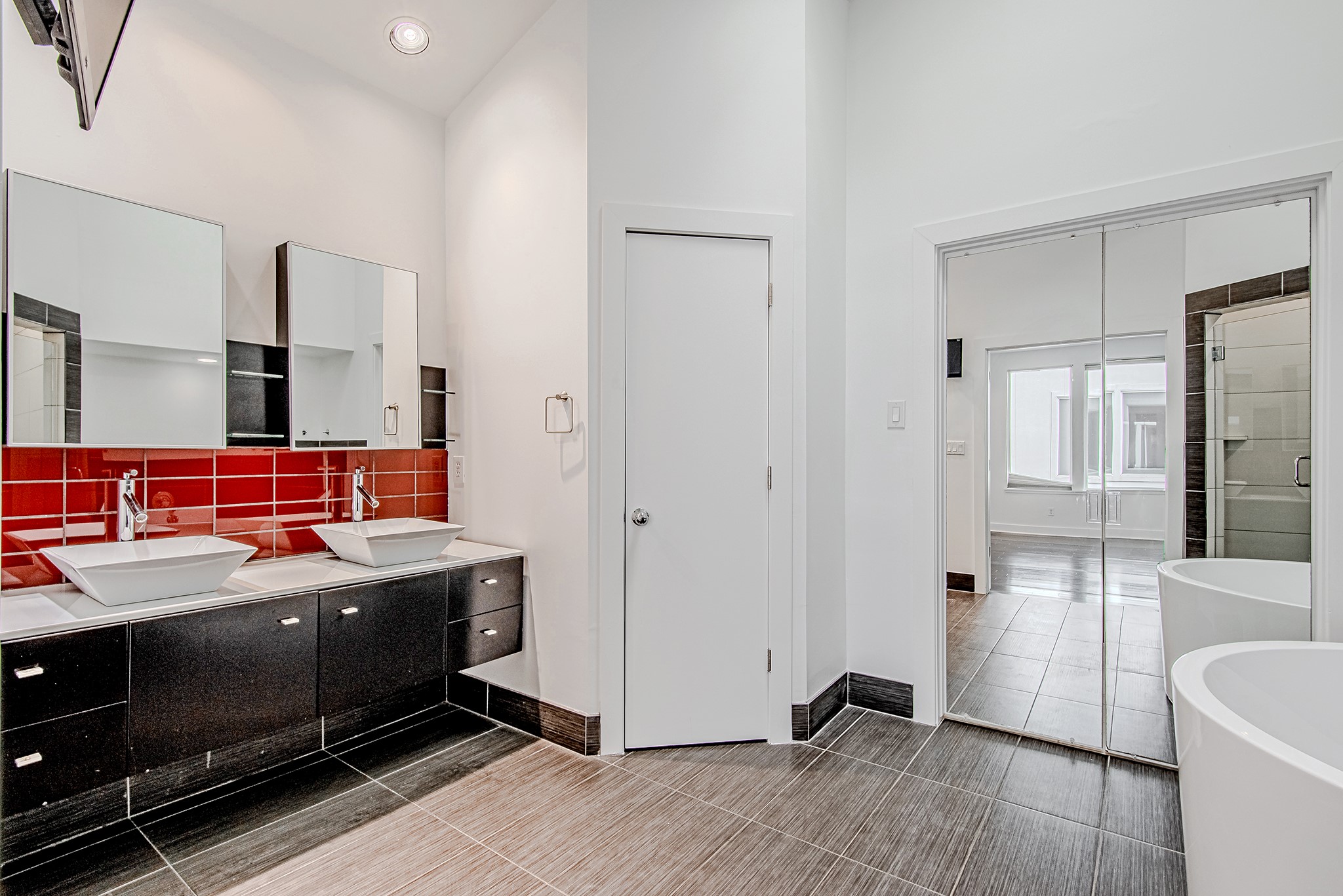 2025 Colquitt Street, Unit E Houston, TX 77098 - Photo 18 of 29 Primary bathroom featuring dual vanities, modern fixtures, and bold accent detailing.