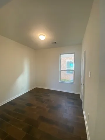 a view of empty room with windows and ceiling fan