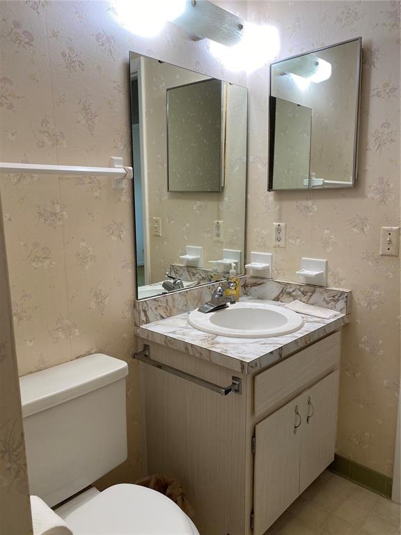 5047 Ferncrest Drive Winter Park, FL 32792 - Photo 19 of 34 a bathroom with a granite countertop sink toilet and mirror