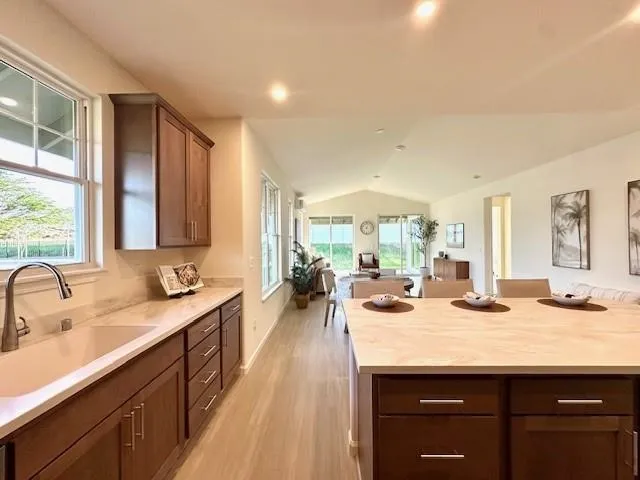 a bathroom with a granite countertop bathtub shower sink vanity and toilet