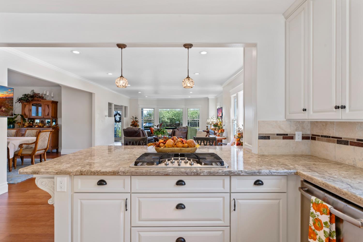 12407 Elm Avenue Patterson, CA 95363 - Photo 19 of 43 a kitchen with stainless steel appliances granite countertop a stove a sink and white cabinets with wooden floor