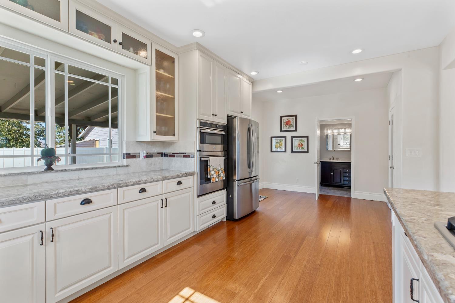 12407 Elm Avenue Patterson, CA 95363 - Photo 20 of 43 a kitchen with granite countertop a refrigerator and wooden floor