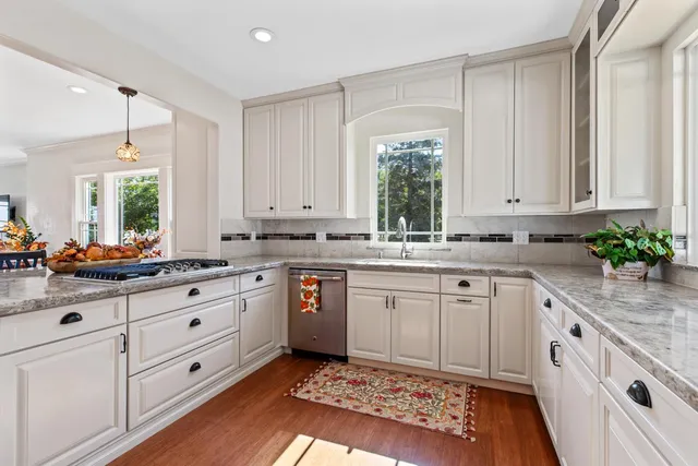 a kitchen with granite countertop white cabinets and white appliances