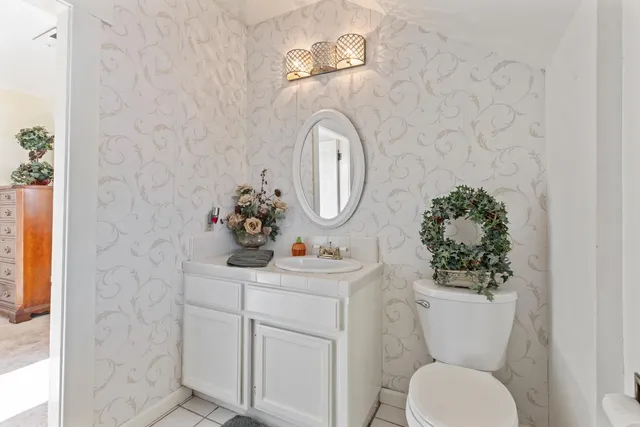a bathroom with a toilet sink vanity and mirror