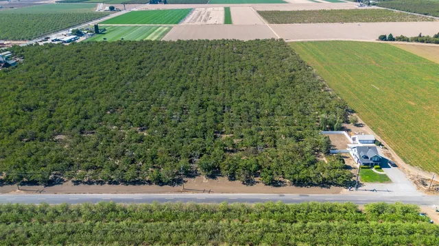 an aerial view of a house with a yard and lake view