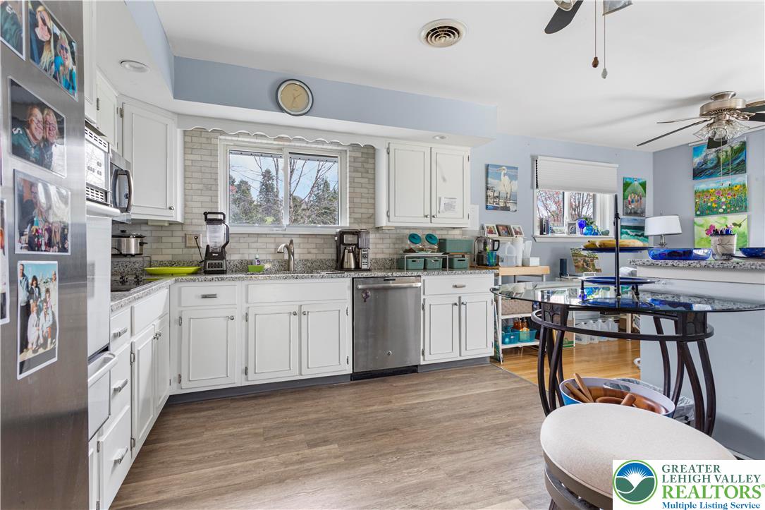910 Gall Road Easton, PA 18040 - Photo 2 of 30 a kitchen with stainless steel appliances kitchen island granite countertop a stove a sink dishwasher and white cabinets with wooden floor