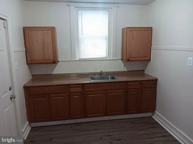 a kitchen with granite countertop cabinets and wooden floor
