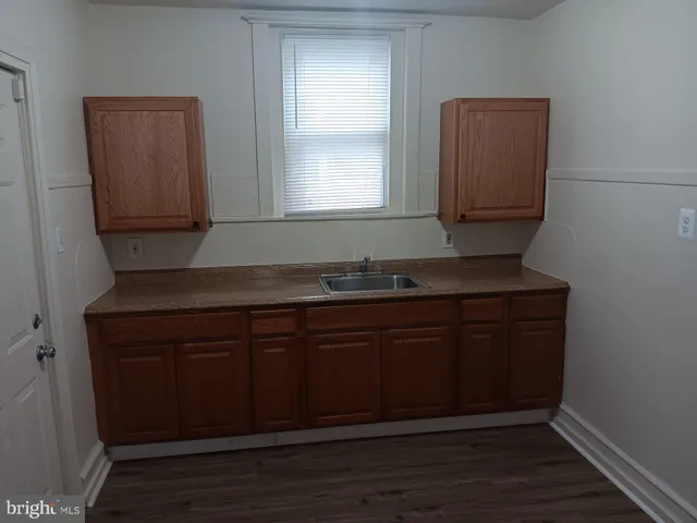 a kitchen with granite countertop cabinets and wooden floor