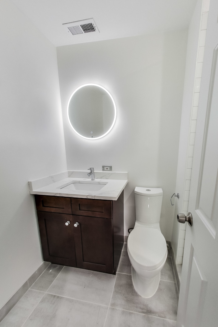 1036 West Monroe Street Chicago, IL 60607 - Photo 17 of 24 a bathroom with a sink vanity mirror and toilet